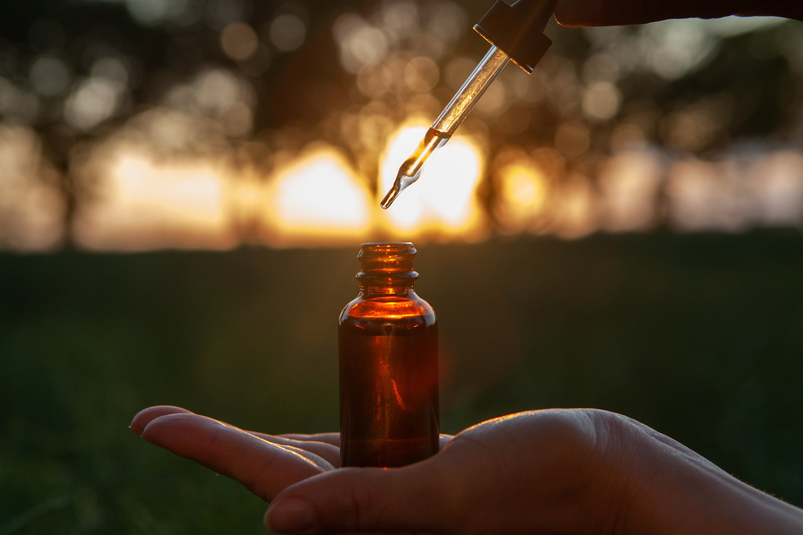 Women holding a dropper bottle of essential oil. Flower therapy - BACH.